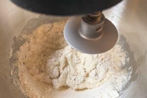 Mehl wird in einer Küchenmaschine mit Knethaken zu Baguette-Teig verarbeitet
