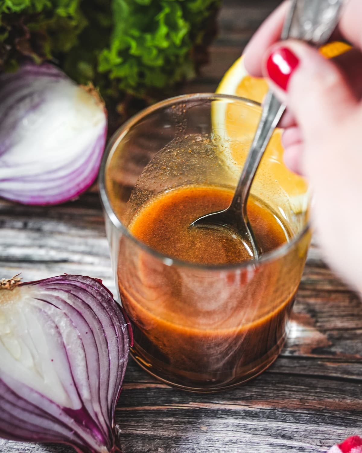 Balsamico Dressing im Glas mit roten Zwiebeln und frischen Zitronen.