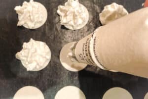 Den Kokosmakronenteig als kleine Haeubchen auf die Oblaten spritzen