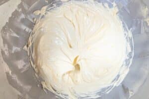 Cremige weiße Frosting-Masse in einer Schüssel mit Spatel für Fingerleckenkuchen-Rezept.