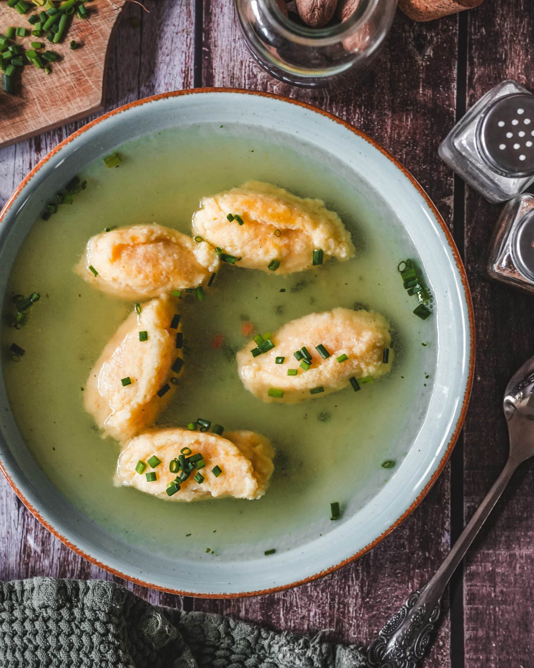 Grießnockerl in klarer Brühe mit Schnittlauch garniert als klassisches Suppenrezept.