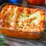 Goldbraun gebackene Kürbis-Lasagne mit Käse und frischen Kräutern in Glasauflaufform.