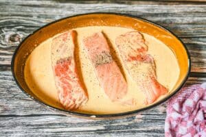 Die Soße über die Lachsfilets gießen und das Lachs-Sahne-Gratin auf der mittleren Schiene 20–25 Minuten backen, bis der Lachs gar und die Soße cremig gebunden ist.