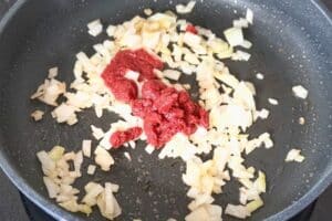 Das Tomatenmark anschwitzen.