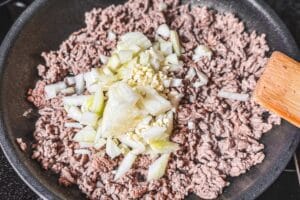Anschließend die Zwiebeln mit anbraten, ebenso den Knoblauch etwas andünsten.
