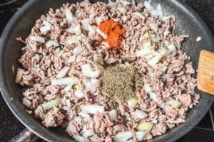 Hackfleisch mit Zwiebeln und Gewürzen in einer Pfanne, zubereitet für einen cremigen Makkaroni Auflauf.