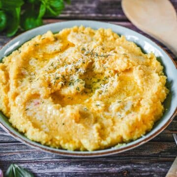 Cremige Polenta mit Parmesan und frischem Thymian und Basilikum.