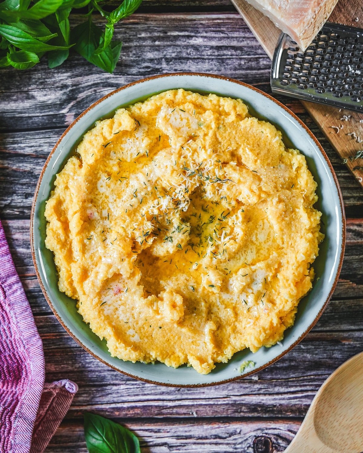 Cremige Polenta mit Parmesan und frischem Thymian und Basilikum.