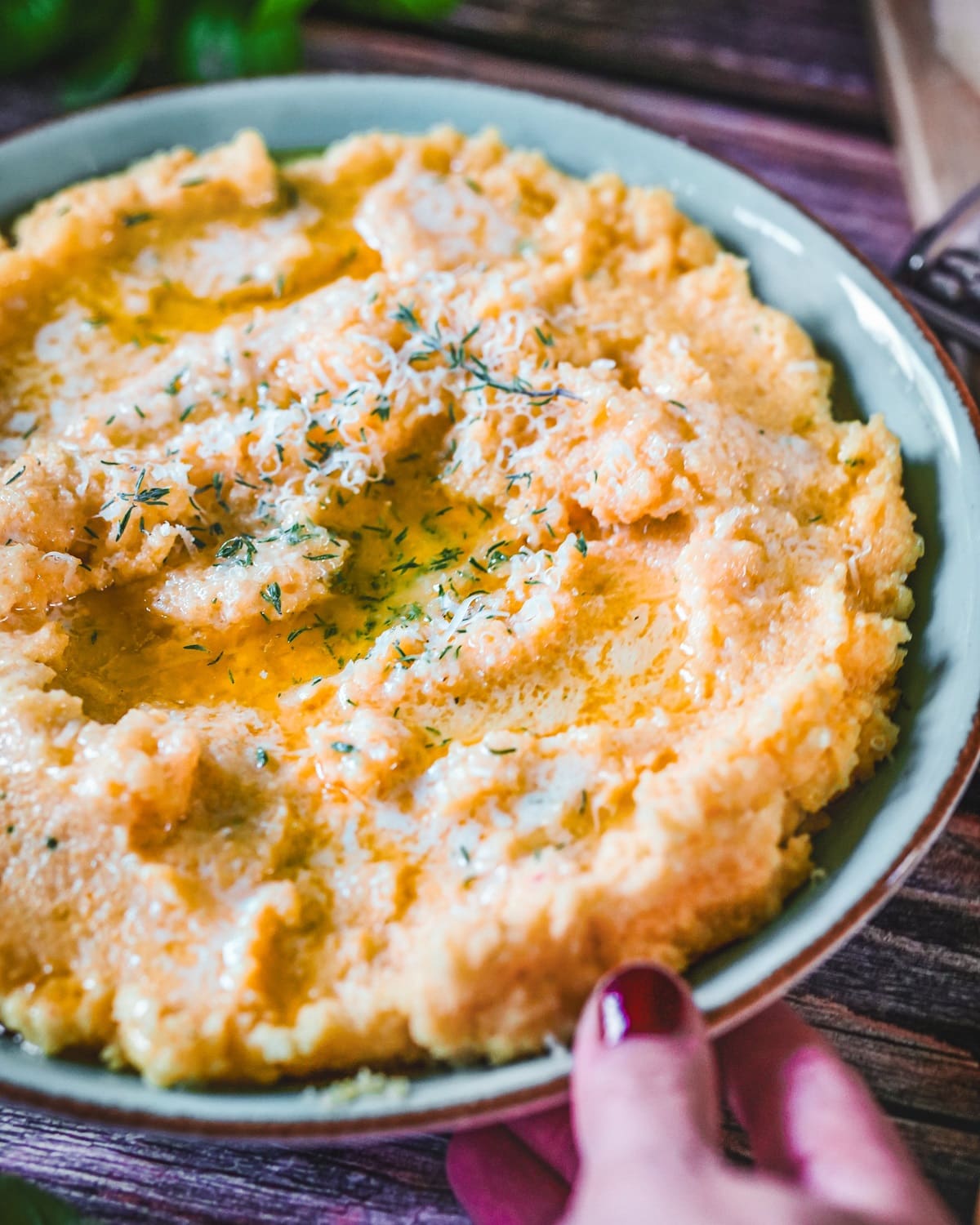 Cremige Polenta mit Parmesan und frischem Thymian und Basilikum.
