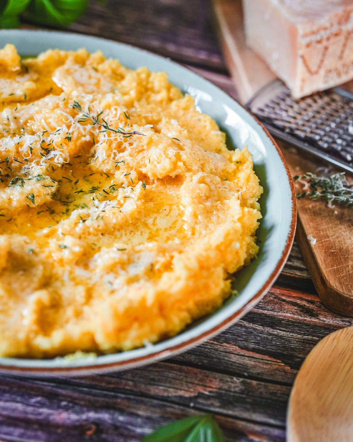 Cremige Polenta mit Parmesan und frischem Thymian und Basilikum.