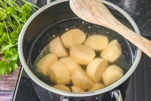 Salzkartoffeln kochen in einem Topf mit Wasser auf dem Campingkocher im Freien.