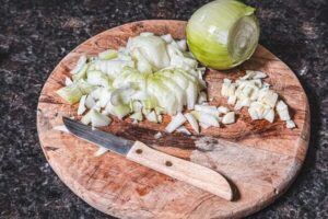 Für die Schmorgurken die Zwiebeln und den Knoblauch fein hacken.