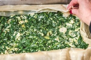 Die Spinat-Feta-Füllung auf dem Filoteig verteilen und glatt streichen.