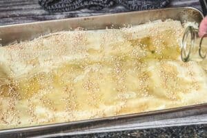 Spanakopita mit Sesam in Backform vor dem Backen vorbereitet