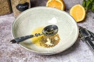 Für die Marinade Olivenöl mit fein gehacktem oder gepresstem Knoblauch, Oregano, italienischen Kräutern, Zitronensaft, Salz und Pfeffer verrühren.