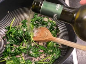 angeduensteten spinat in pfanne mit weisswein abloeschen