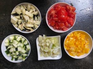 aubergine, tomaten, zucchini, fenchel und paprika fuer das ratatouille rezept klein geschnitten