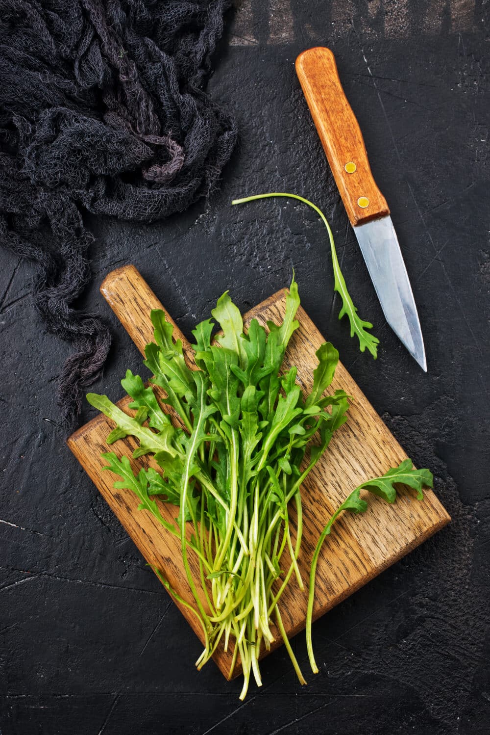frischer rucola auf kuechenbrett