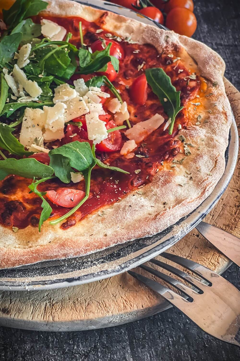 pizza mit rucola tomaten und parmesan
