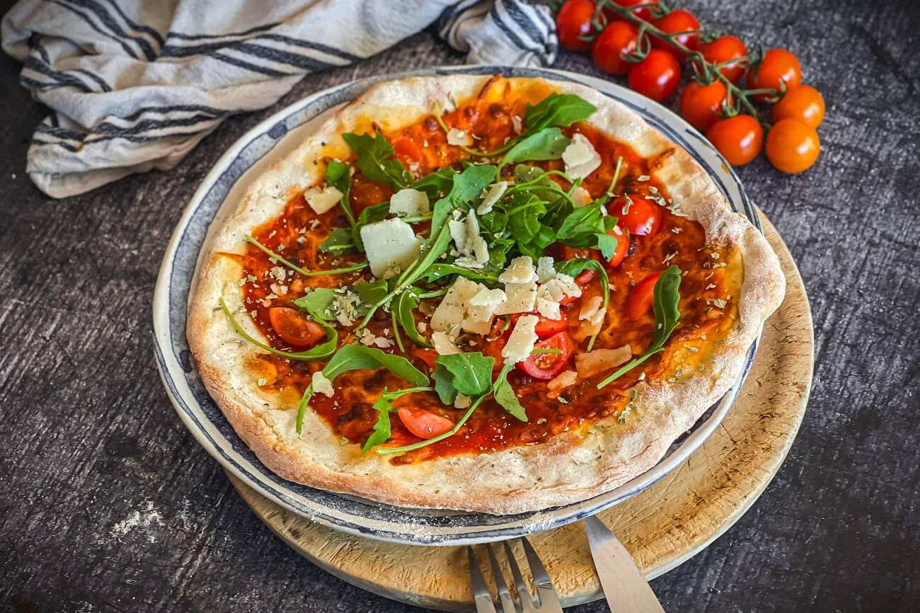 Pizza Rucola mit Tomaten und Parmesan