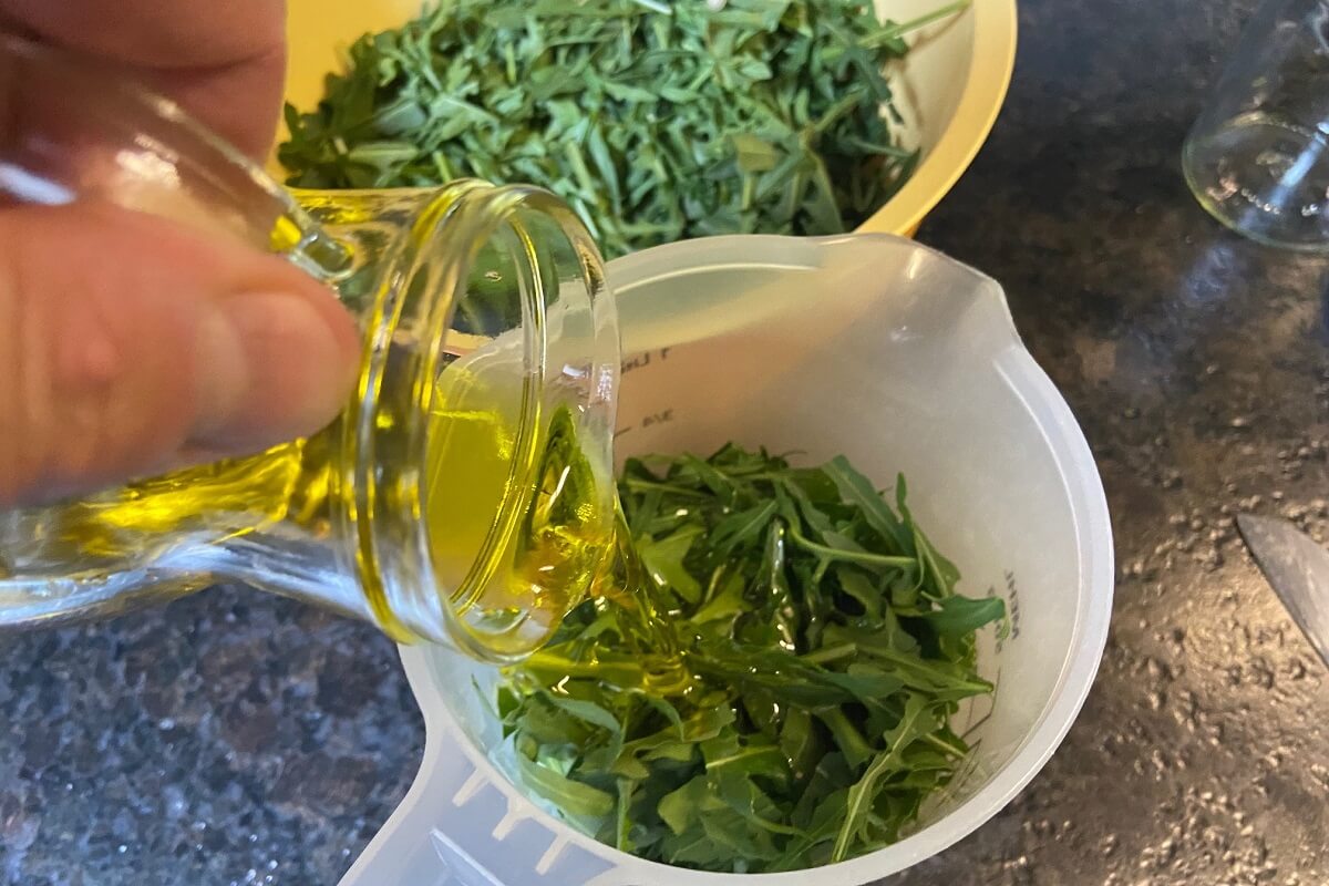 rucola und olivenoel in ein gefaess zum puerieren geben